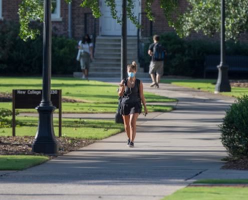 A student wears a face covering on campus.